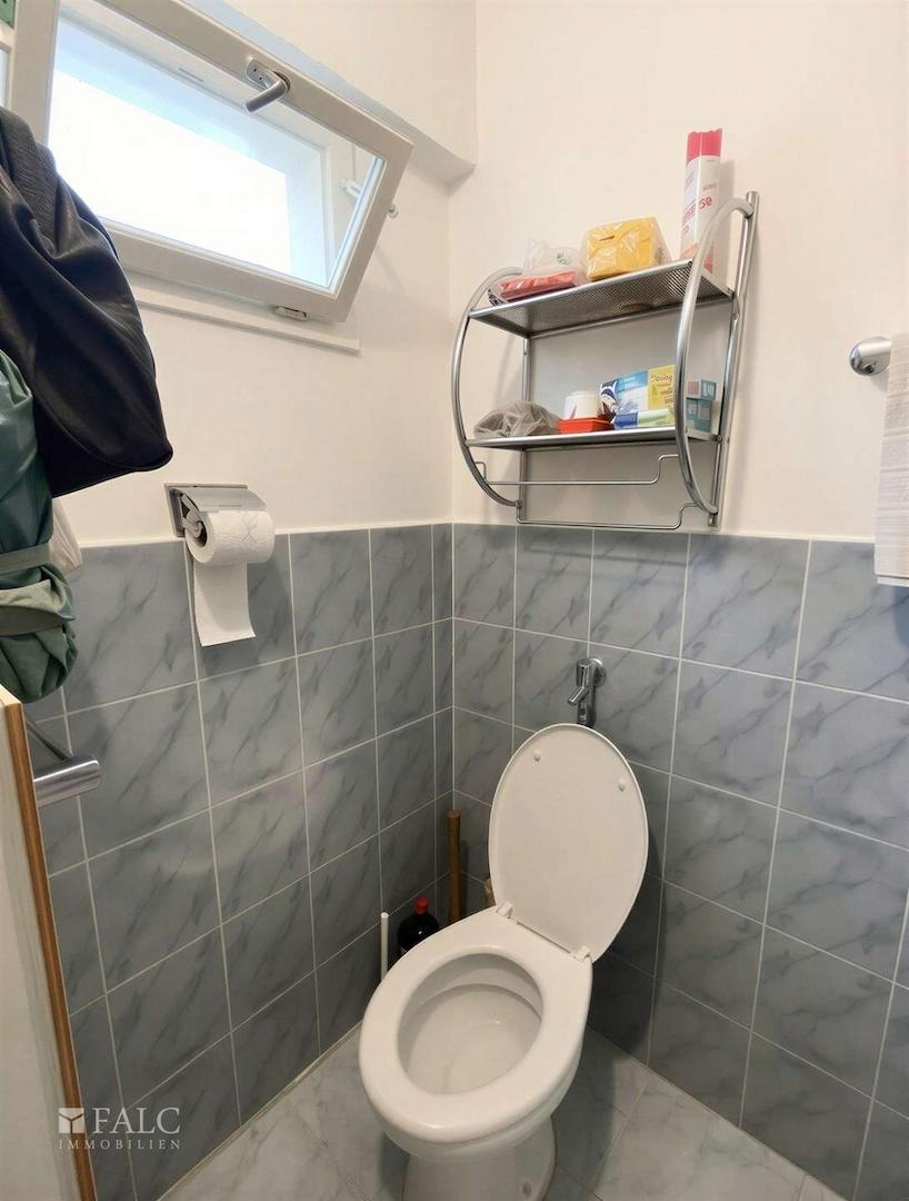 Lichtdurchflutetes Gäste-WC mit praktischem Wandregal und elegantem Fliesenspiegel - (KI generiert)