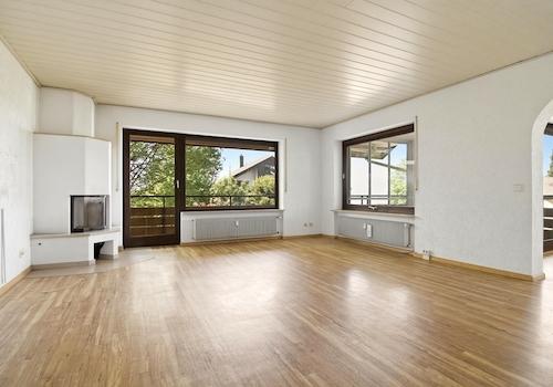 Helles Wohnzimmer mit Kamin und Zugang zum Balkon