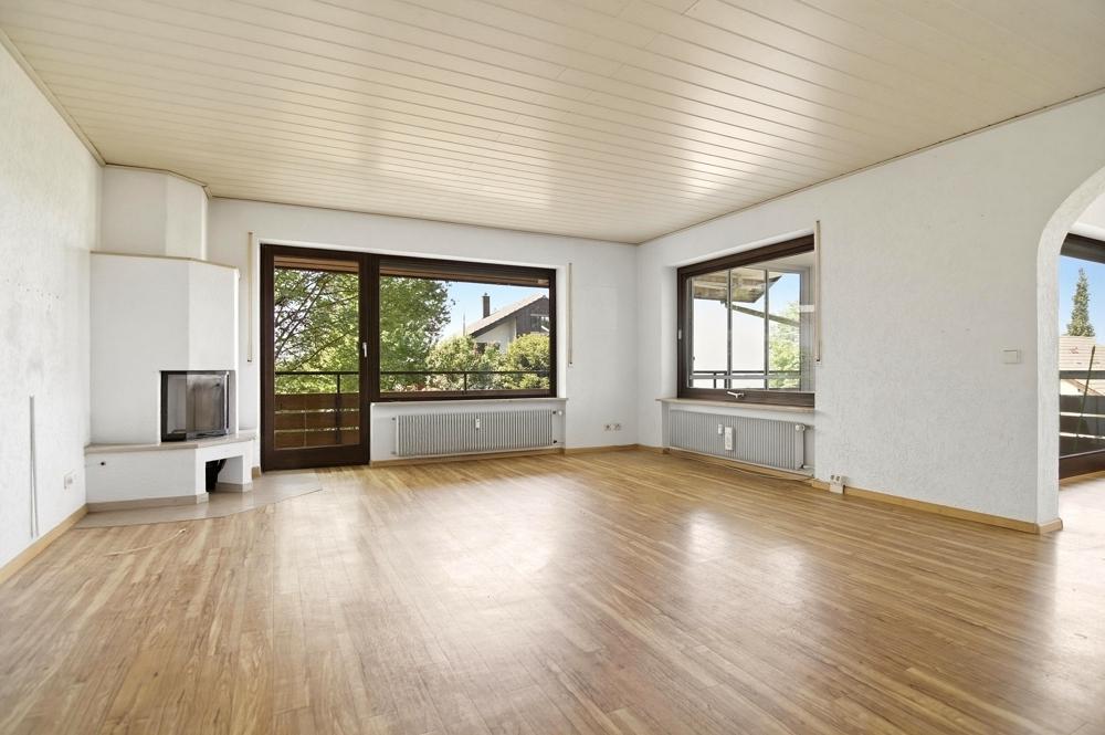 Helles Wohnzimmer mit Kamin und Zugang zum Balkon