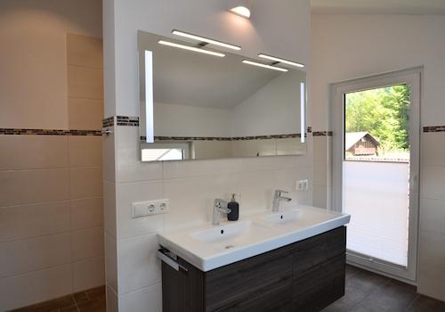 Badezimmer mit Doppelwaschbecken, Regendusche und WC-Niesche