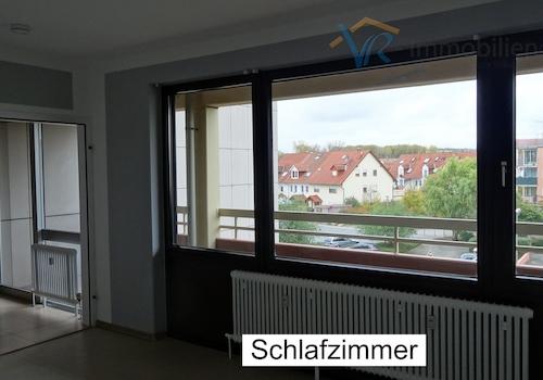 Schlafzimmer mit Blick auf Wohnzimmer und Balkon