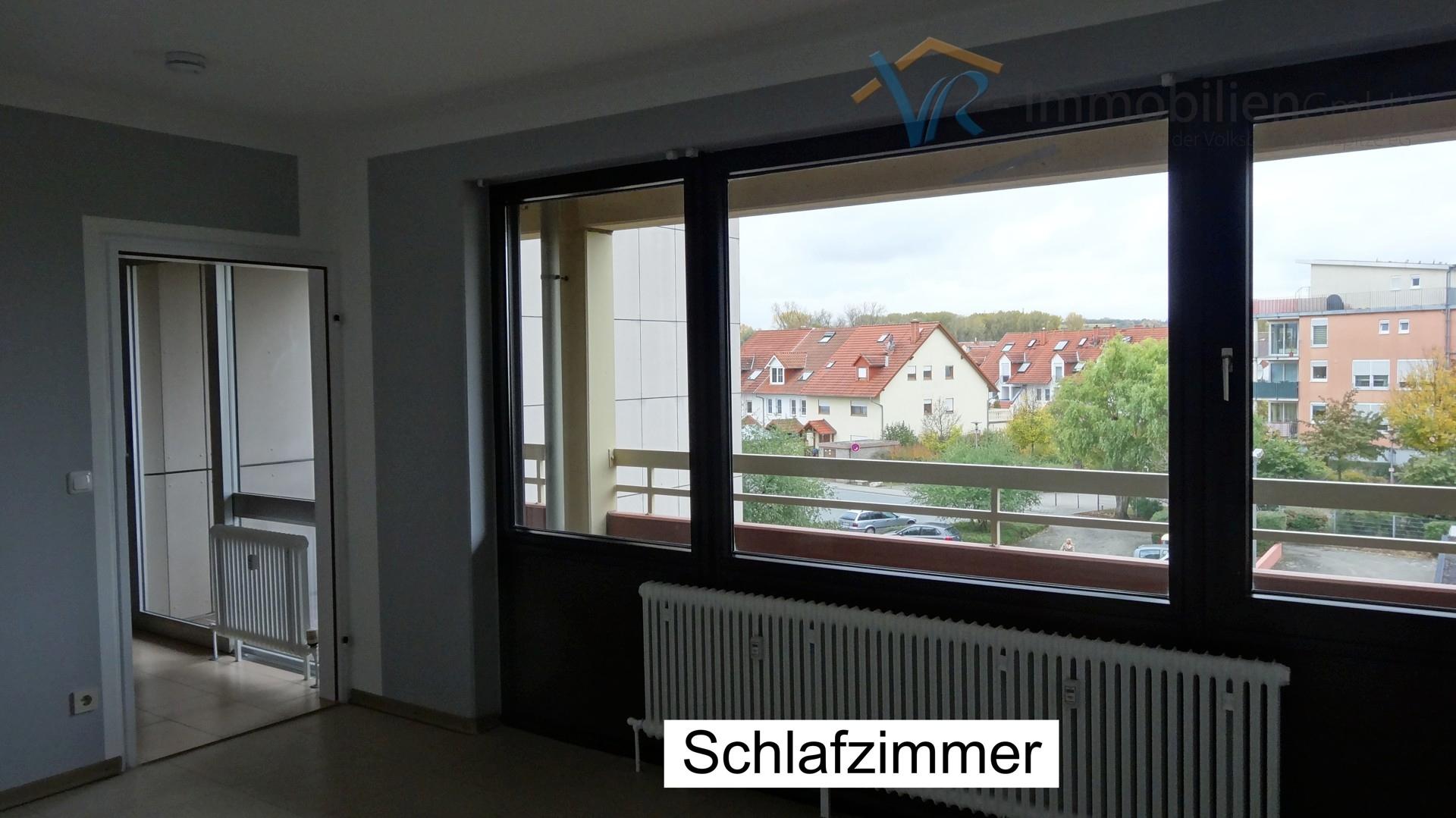 Schlafzimmer mit Blick auf Wohnzimmer und Balkon