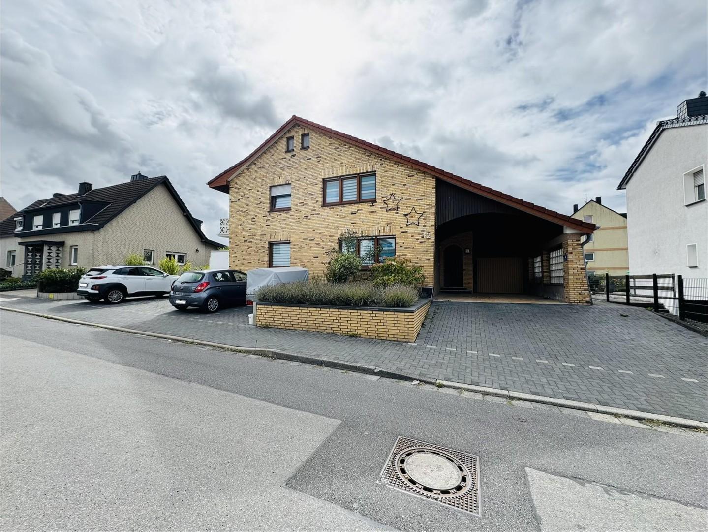 Blick aufs Haus mit Parkfläche