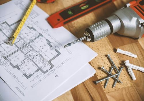 close-up-of-construction-blueprint-with-tools-like-drill-and-screws-on-a-wooden-table-1ZXatmSuglj-GjkkwwW95w (1)