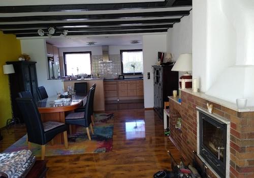 Wohnzimmer mit Kamin und Küche