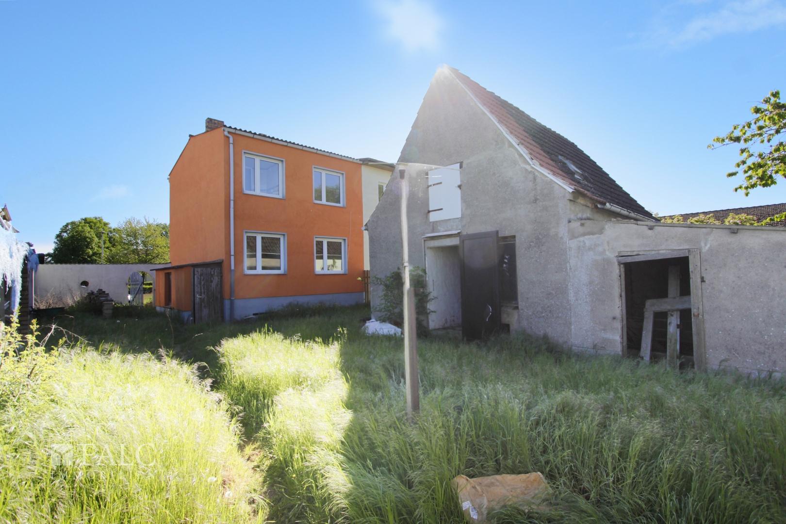 Blick auf Haus und Nebengebäude vom Garten