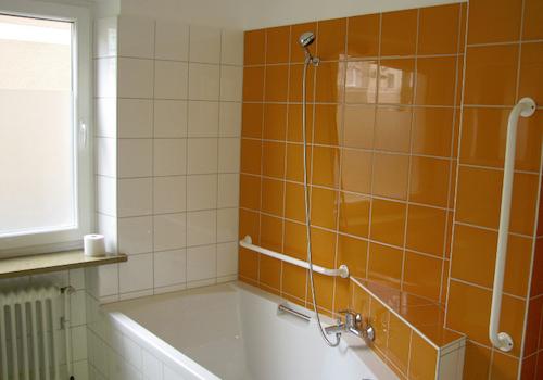 Sonniges Badezimmer mit Badewanne und Dusche