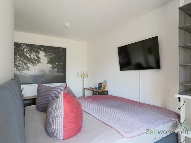 Bett und TV hinter dem Raumteiler