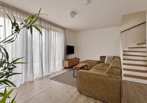 kaufen-freistehendes-ferienhaus-wolphaartsdijk-wohnzimmer-sitzecke-treppe-recreatieadviseurs-vakantiehuistekoop-nl.jpg