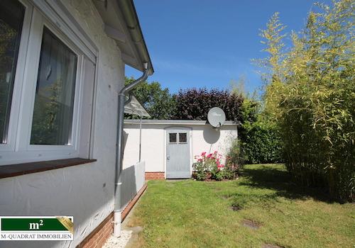 Gartenblick auf Garage mit Nebeneingang