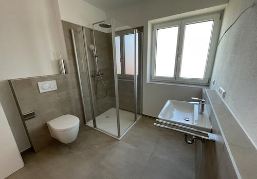 Bad mit Dusche, WC, Waschbecken und Waschmaschinenanschluss