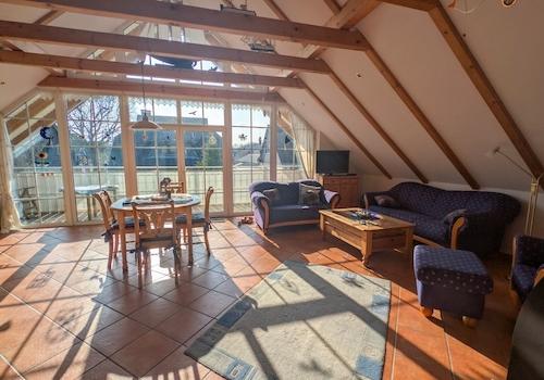Wohn- und Esszimmer im Dachgeschoss mit Zugang zum Balkon