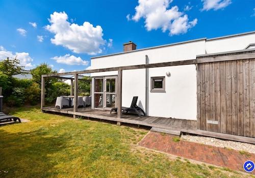 kaufen-freistehendes-ferienhaus-ouddorp-seitenansicht-holzterrasse-pergola-recreatieadviseurs-vakantiehuistekoop-nl.jpg
