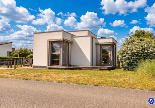 kaufen-freistehendes-ferienhaus-ouddorp-aussenansicht-rueckseite-holzterrasse-recreatieadviseurs-vakantiehuistekoop-nl.jpg