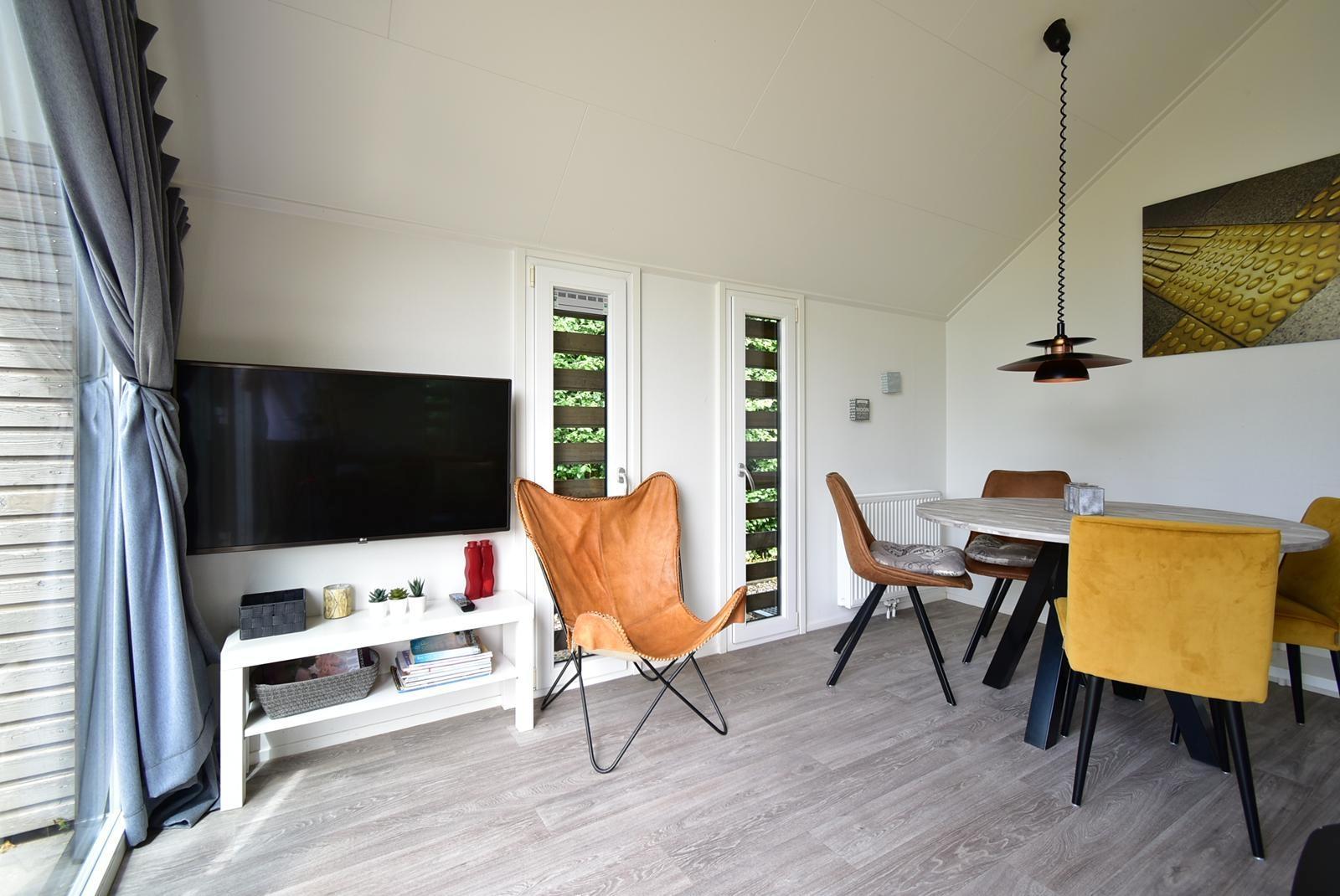 kaufen-freistehendes-ferienhaus-olburgen-wohnzimmer-mit-tv-moebel-und-essbereich-recreatieadviseurs-vakantiehuistekoop-nl.jpg
