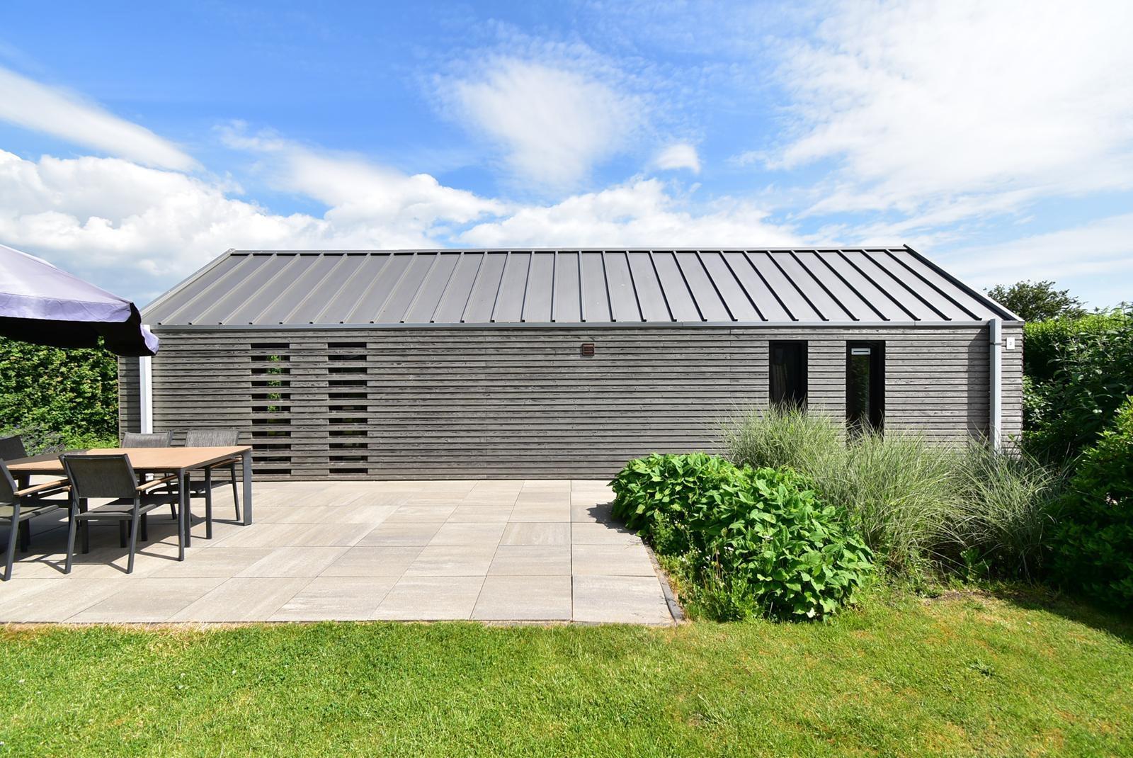 kaufen-freistehendes-ferienhaus-olburgen-terrasse-mit-seitenansicht-moderne-holzfassade-recreatieadviseurs-vakantiehuistekoop-nl.jpg