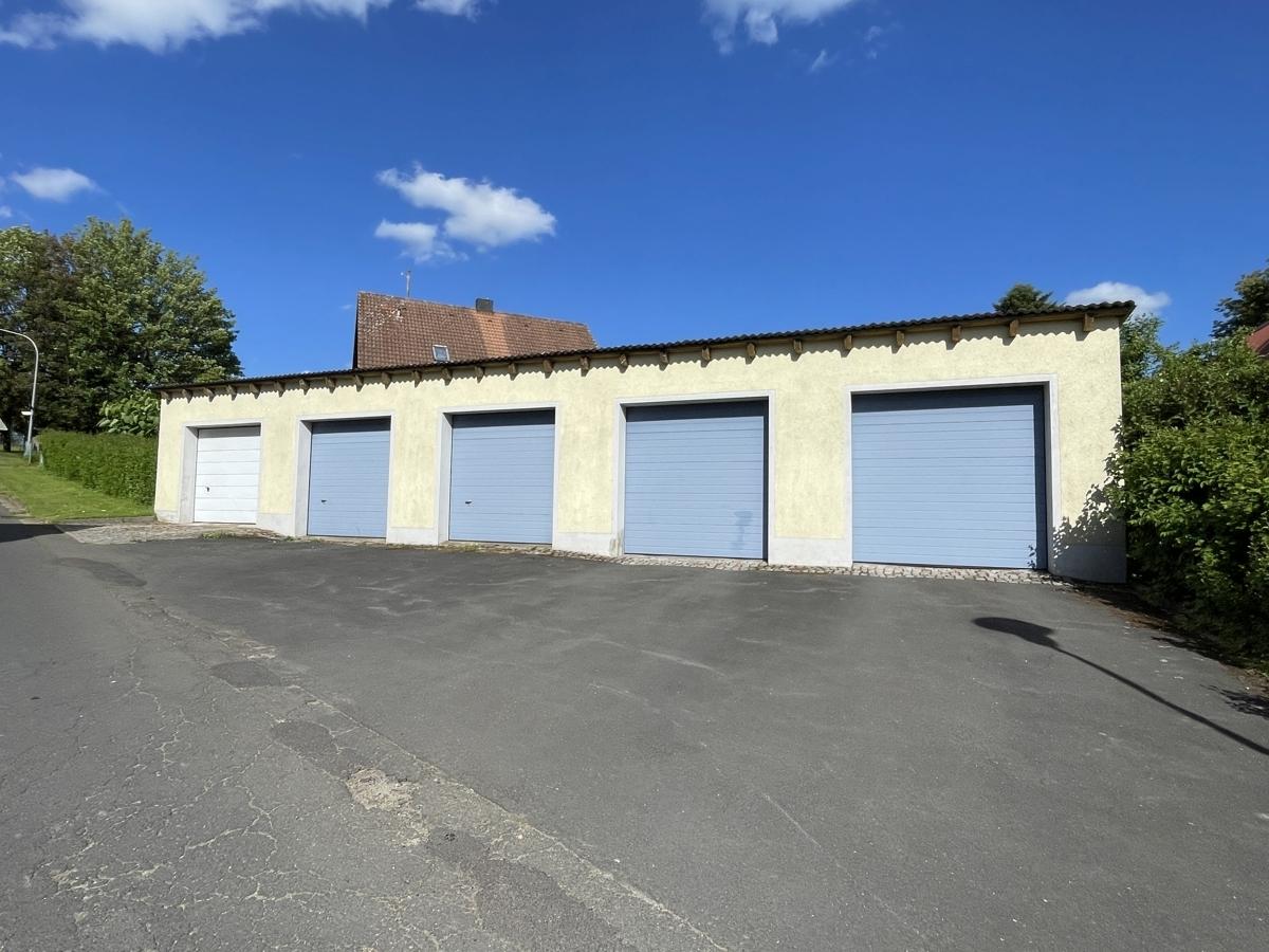 Garage (ganz links mit Rolltor)