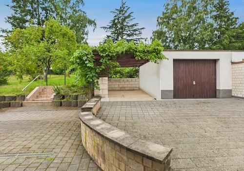 Terrasse mit Blick auf Pergola und Garage