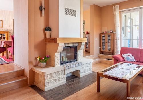 Wohnzimmer mit Kamin und Zugang zur überdachten Terrasse