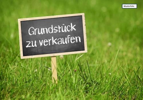 Grundstück_mit_Verkaufsschild_Musterfoto