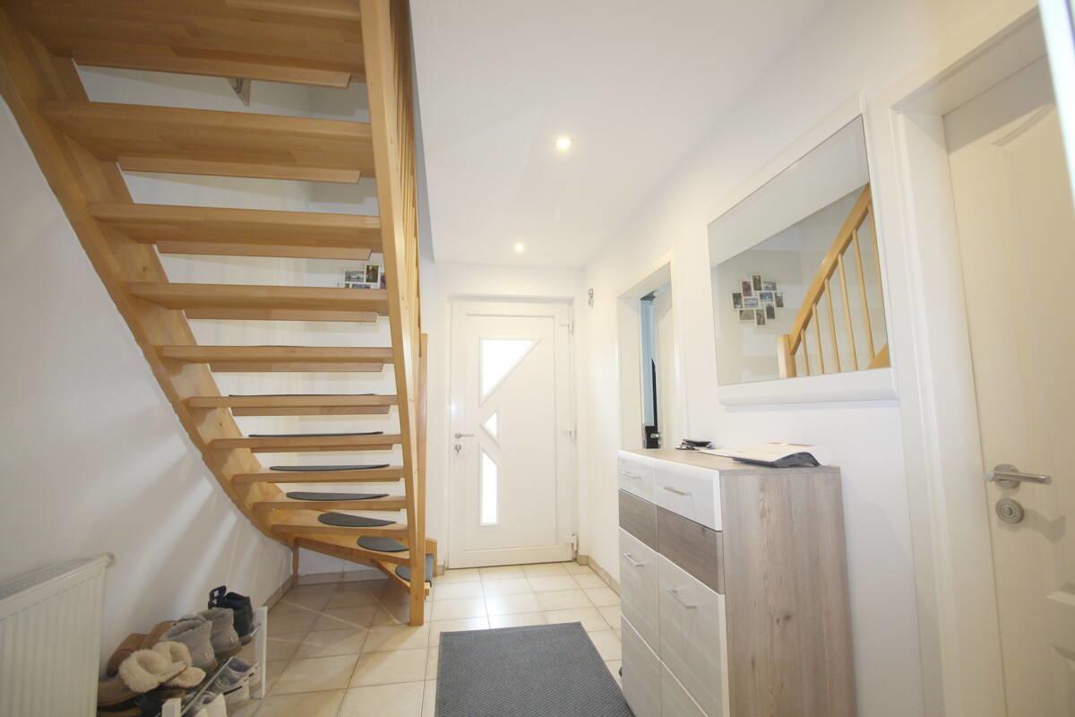 Eingangsbereich mit Flur u. Holztreppe ins OG