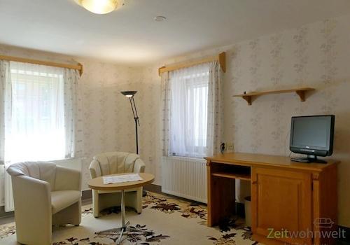 Wohnzimmer, TV, Schreibtisch und Sessel