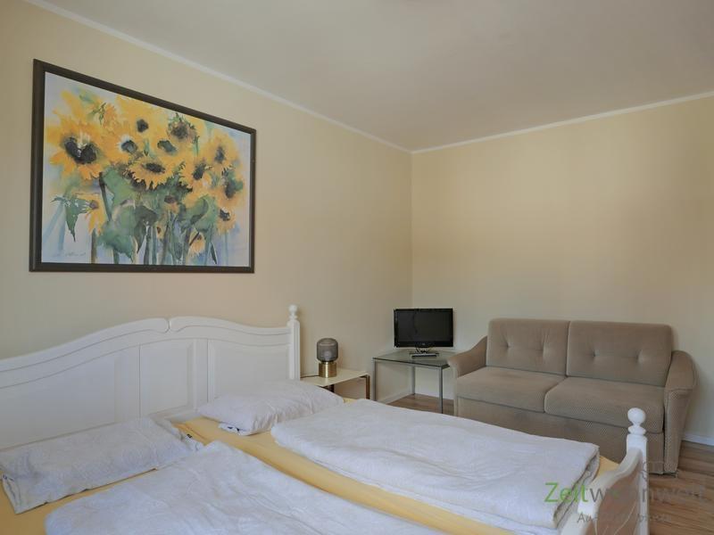 TV und Sofa im Schlafzimmer