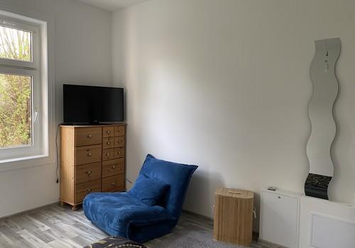 TV und Sessel mit Schlaffunkt.
