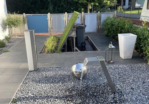 Zaun, Mülltonnen, Wasserspiel