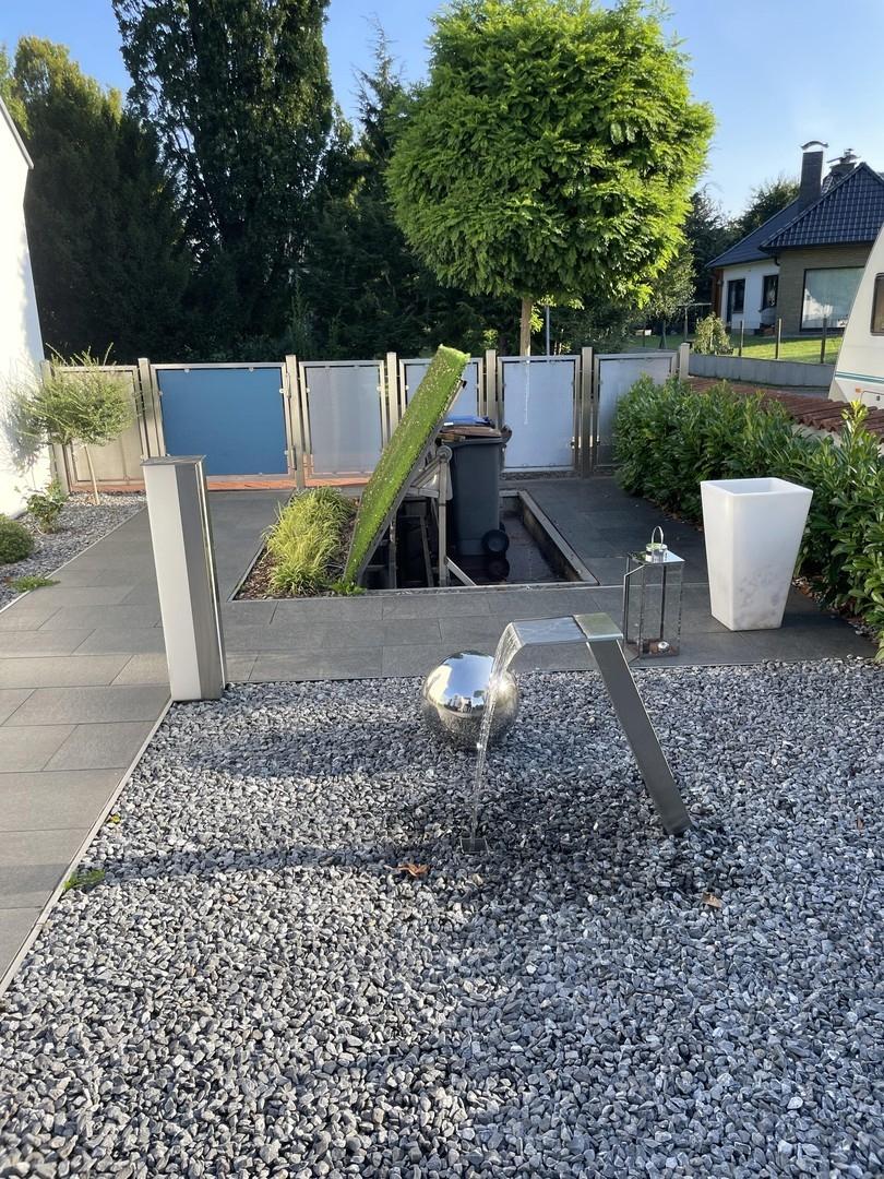 Zaun, Mülltonnen, Wasserspiel