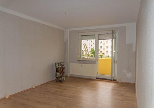 Stube mit Balkon und Laminatboden.