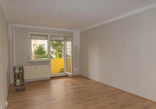Stube mit Balkon und Laminatboden.