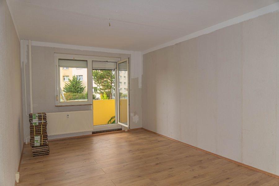 Stube mit Balkon und Laminatboden.