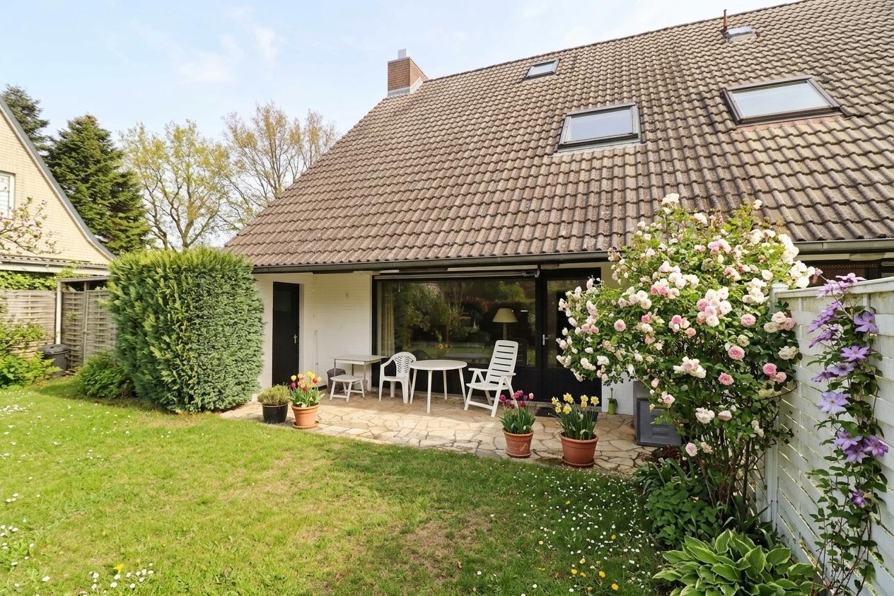Blick vom Garten auf die Terrasse mit der Garagentür
