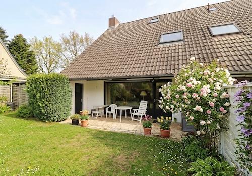 Blick vom Garten auf die Terrasse mit der Garagentür