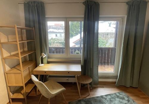 Schreibtisch vor dem Balkon