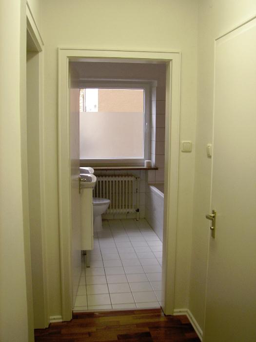 Ansicht Badezimmer vom Flur mit Gäste-WC Türe rechts
