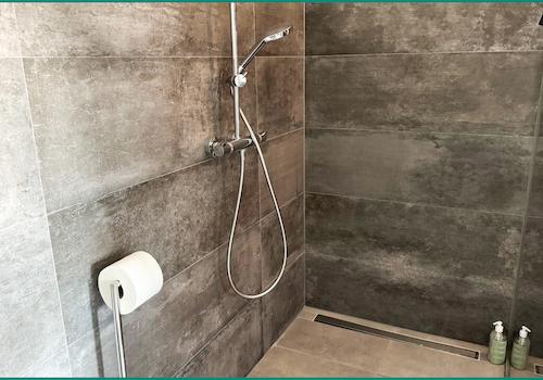 ...und großer bodengleicher Dusche mit verspiegelter Trennwand