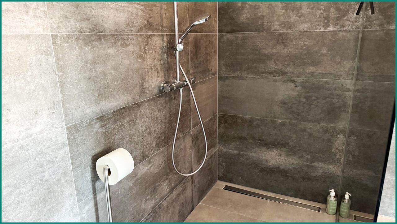 ...und großer bodengleicher Dusche mit verspiegelter Trennwand