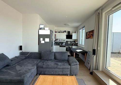 Wohnzimmer mit Terrassenzugang und offener Küche
