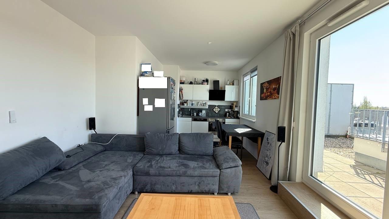 Wohnzimmer mit Terrassenzugang und offener Küche