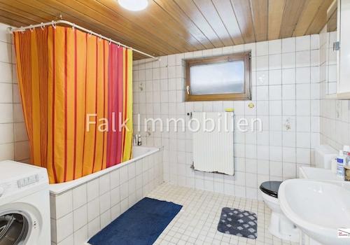 Badezimmer mit Badewanne und Waschmaschinenanschluss im Untergeschoss