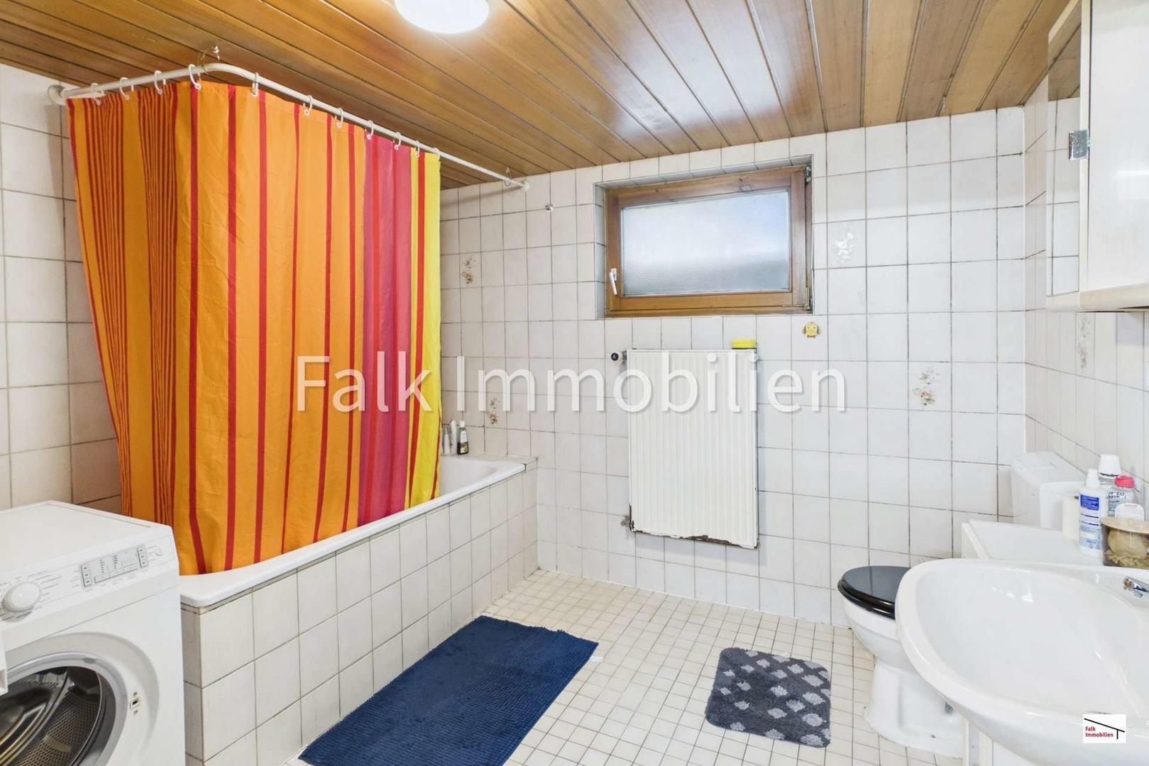 Badezimmer mit Badewanne und Waschmaschinenanschluss im Untergeschoss