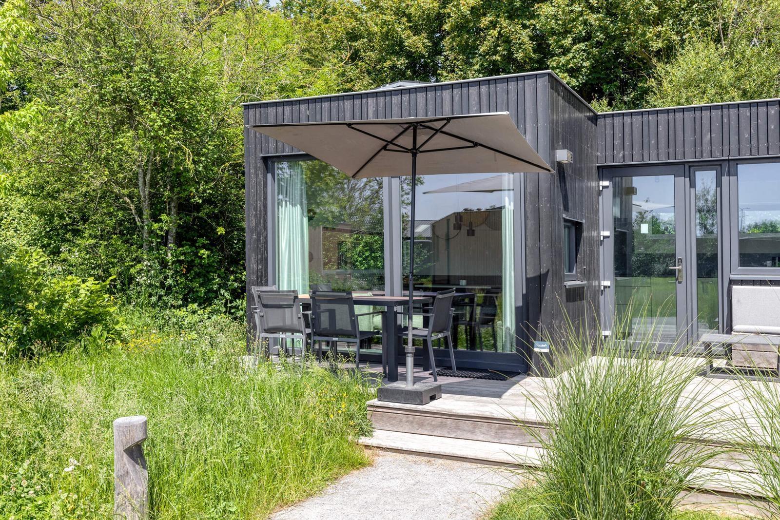 kaufen-freistehendes-ferienhaus-kamperland-terrasse-aussenessbereich-und-sonnenschirm-recreatieadviseurs-vakantiehuistekoop-nl.jpg
