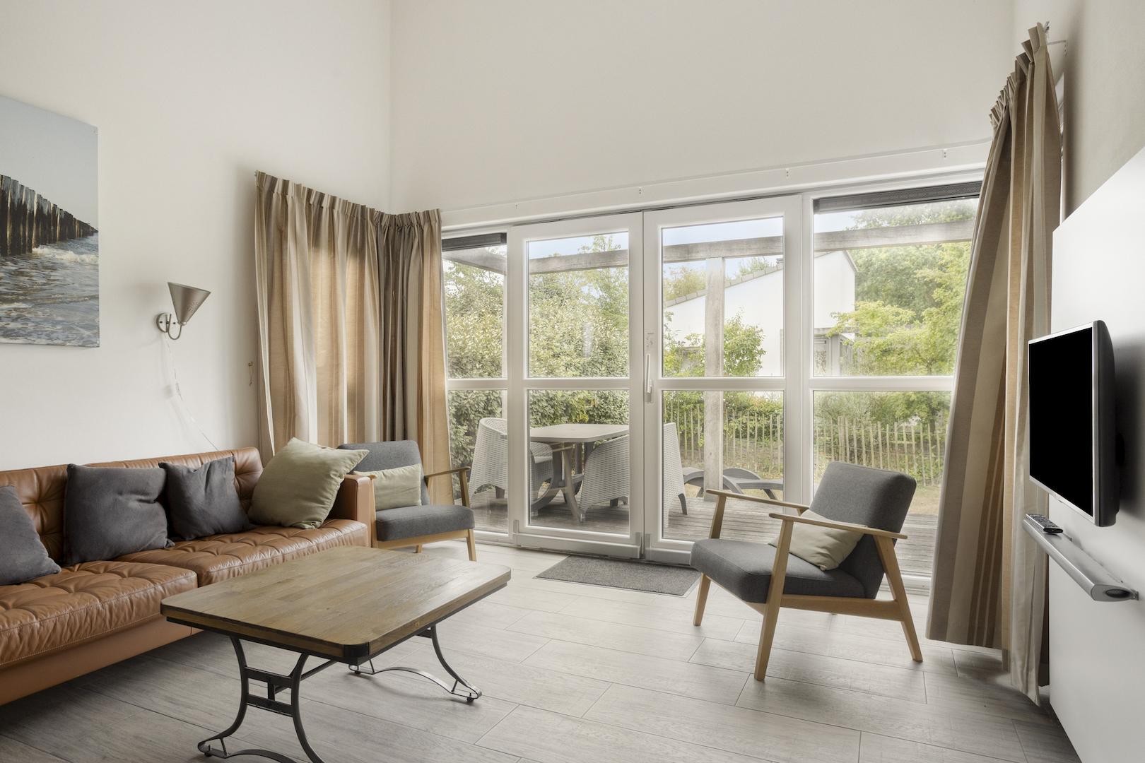 kaufen-freistehendes-ferienhaus-ouddorp-wohnzimmer-schiebetuer-und-terrassenaussicht-recreatieadviseurs-vakantiehuistekoop-nl.jpg