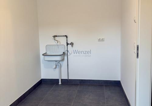 Praktischer Hauswirtschaftsraum mit Waschbecken und Anschlüssen