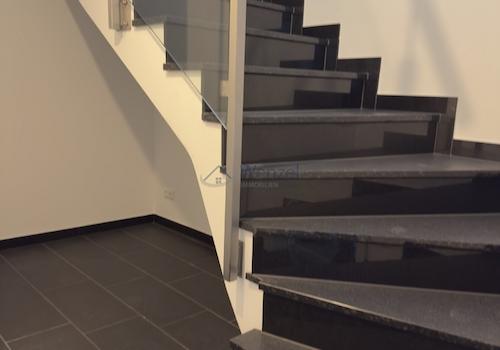 Moderne Treppe mit Glasgeländer und hochwertiger Metallhandlauf
