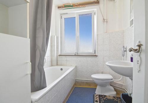 Badezimmer mit Fenster und Badewanne