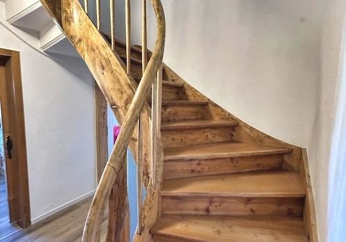 KI-generiert: urige Massivholztreppe ins OG