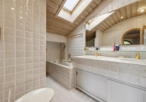 Das Badezimmer mit Badewanne und Dusche